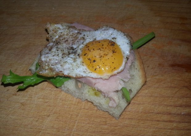 Fotografia przedstawiająca Jajko przepiórcze z rukolą i szynką na chlebie