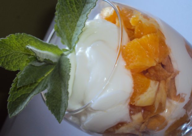 Fotografia przedstawiająca Jogurt z płatkami i pomarańczą
