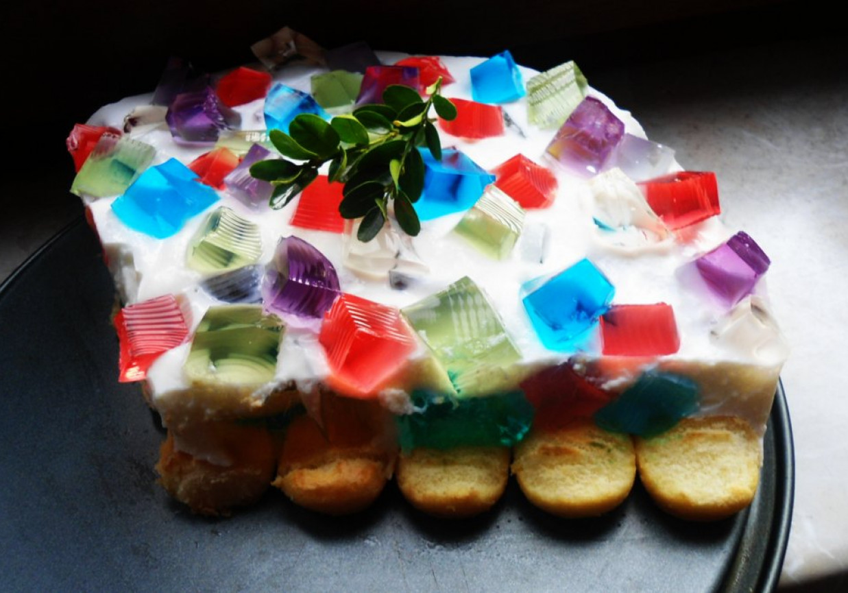 Jogurtowiec z kolorowymi kostkami galaretki na biszkoptach foto