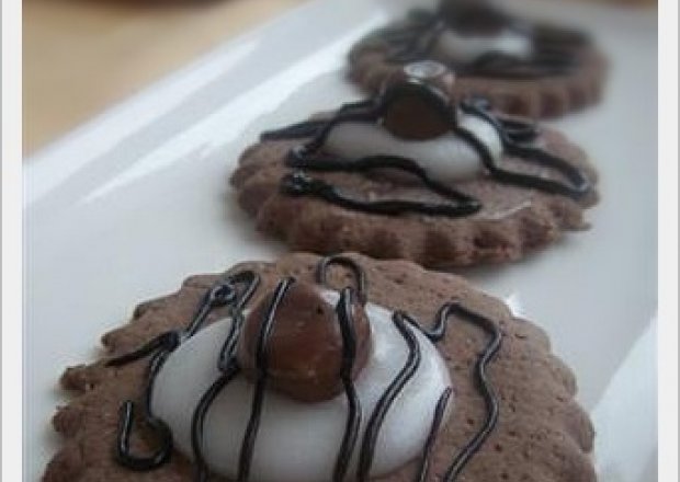Fotografia przedstawiająca Kakaowe ciasteczka z lukrem i kokosem w czekoladzie