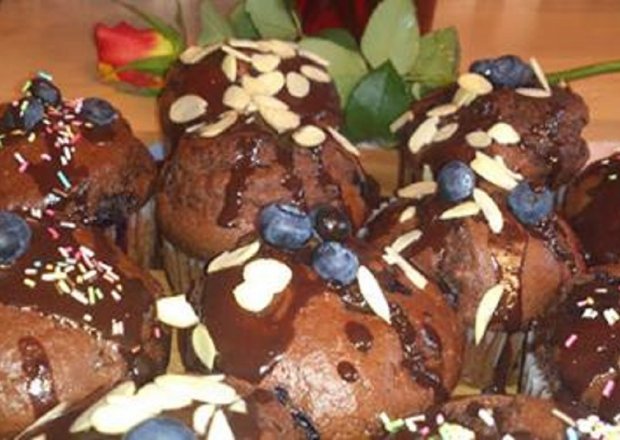 Fotografia przedstawiająca Kakaowe muffiny z czekoladą i borówkami.