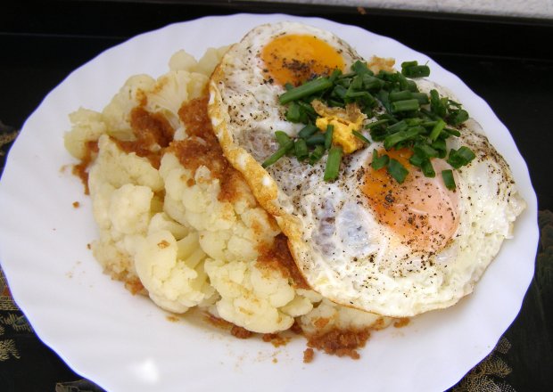 Fotografia przedstawiająca kalafior z jajkiem sadzonym na lekki letni obiad...