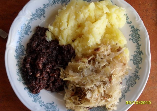 Fotografia przedstawiająca Kaszanka z cebulką, ziemniakami i kapustą kiszoną.