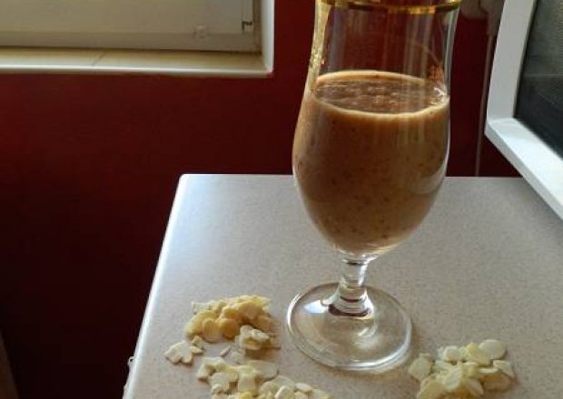Fotografia przedstawiająca Koktajl bananowo-czereśniowy na soku i mleku z płatkami migdałowymi.