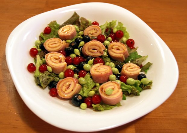 Fotografia przedstawiająca kolorowa sałatka z szynkowymi ślimaczkami