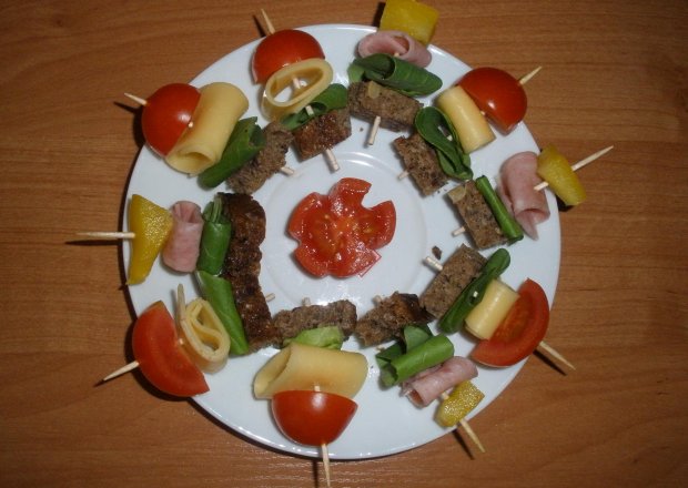 Fotografia przedstawiająca Koreczki z chlebem, sałatą, żółtym serem, mielonką, papryką i pomidorkami