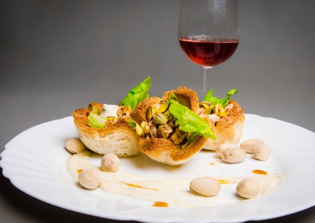 Fotografia przedstawiająca Koszyczki chlebowe z sałatką z piersi kurczaka i pistacjami oblane sosem vinaigrette