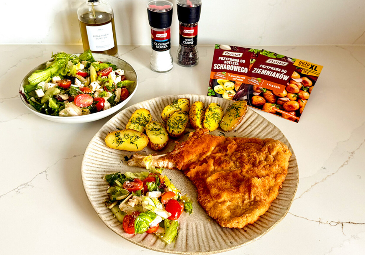 Kotlet schabowy z kością z pieczonymi ziemniaczkami i sałatką foto