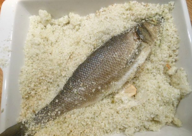 Fotografia przedstawiająca Labraks pieczony w soli morskiej i ziołach