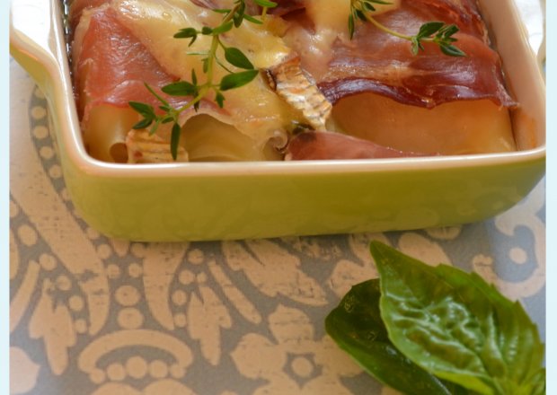 Fotografia przedstawiająca lasagne pachnące prosciutto , ziołami i serem