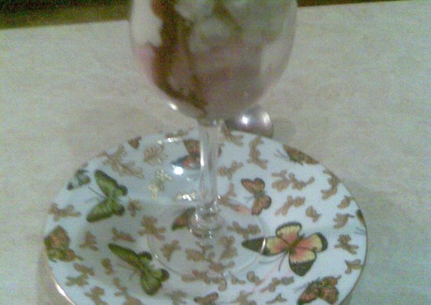 Fotografia przedstawiająca lody z bezą, bitą śmietaną i sosem owocowym