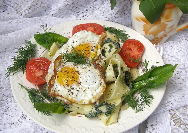 Fotografia przedstawiająca makaron parppadelle ze szpinakiem, mascarpone i jajkami sadzonymi...