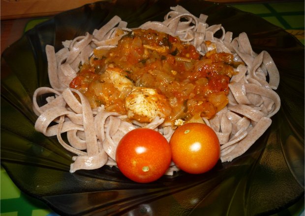 Fotografia przedstawiająca Makaron razowy z sosem pomidorowym i kawałkami kurczaka.