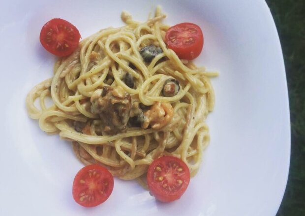 Fotografia przedstawiająca Makaron spaghetti z kurkami, wędzonym łososiem i kremowym sosem parmezanowym.