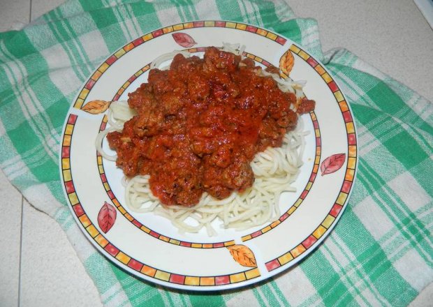 Fotografia przedstawiająca Makaron spaghetti z mięsem mielonym w sosie pomidorowym.
