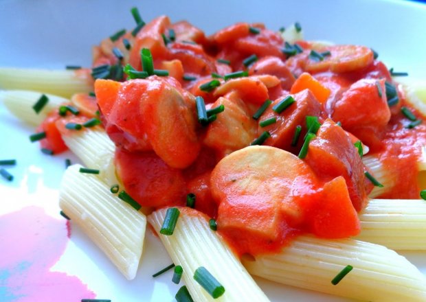 Fotografia przedstawiająca Makaron z kiełbasą, pieczarkami i marchewką w sosie pomidorowo-śmietanowym