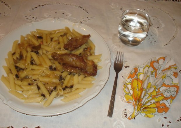 Fotografia przedstawiająca makaron z sosem grzybowym ze sztuką  mięsa