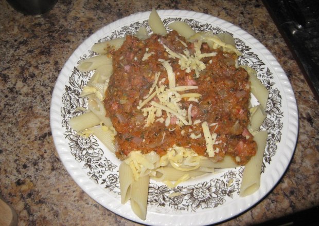 Fotografia przedstawiająca makaron z sosem pomidorowym i kiełbasą
