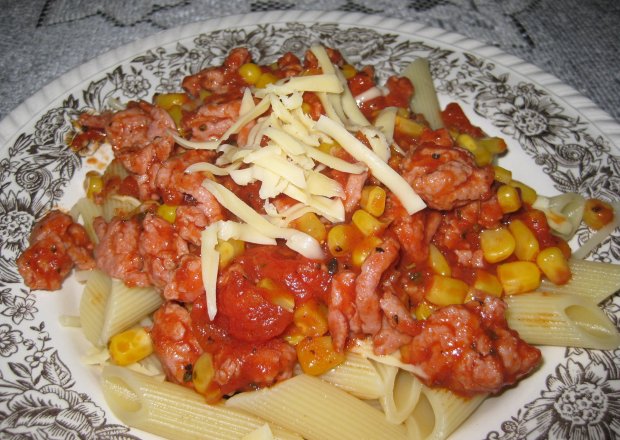 Fotografia przedstawiająca makaron z sosem pomidorowym i kukurydzą