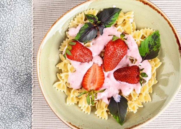 Fotografia przedstawiająca Makaron z truskawkami i smietaną,mniam mniam dla dzieci