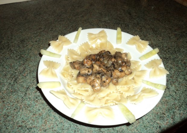 Fotografia przedstawiająca Makaronowe kokardki w sosie pieczarkowo serowym z kosteczkami filetowymi.
