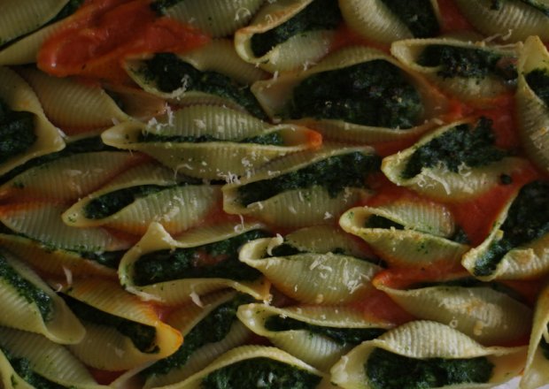 Fotografia przedstawiająca Makaronowe muszle nadziewane szpinakiem i fetą, zapieczone w sosie pomidorowym