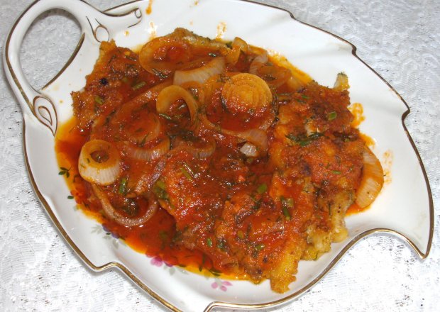Fotografia przedstawiająca małe filety dorsza z koperkiem smażone i sosie pomidoroywm z cebulą...