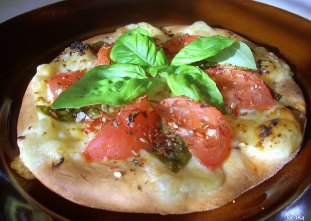 Fotografia przedstawiająca Małe pizze z białym oscypkiem, pomidorami i bazylią