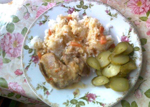 Fotografia przedstawiająca Mięso z sosem, ryżem i ogórkami