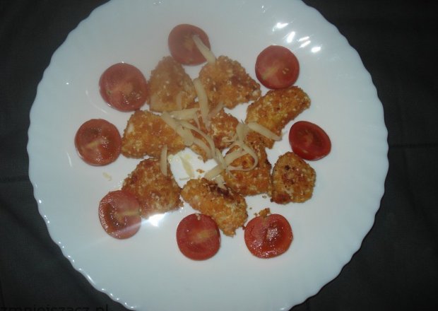 Fotografia przedstawiająca Mini Fileciki w panierce z sezamem- podane z pomidorkami koktajlowymi