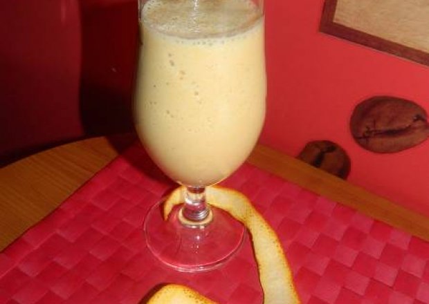 Fotografia przedstawiająca Mleczny koktajl bananowo - pomarańczowy z miodem.
