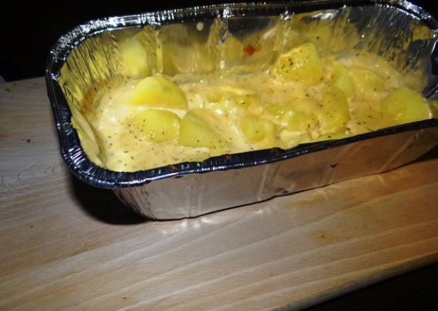 Fotografia przedstawiająca młode ziemniaki pieczone w sosie serowym