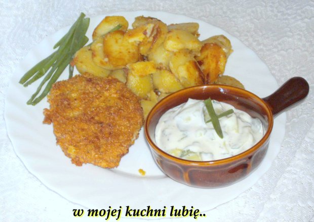 Fotografia przedstawiająca młode ziemniaki z czosnkiem, kotletem schabowym i mizerią na obiad...