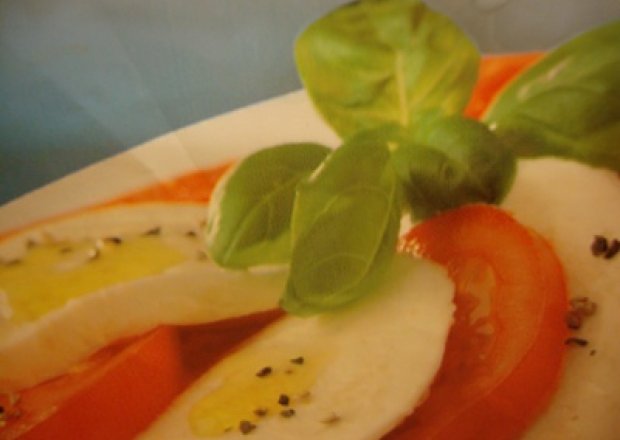 Fotografia przedstawiająca Mozarella z pomidorami i bazylią