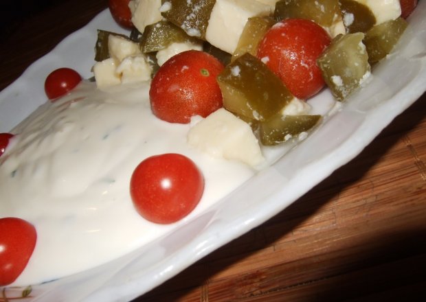 Fotografia przedstawiająca Mozarella z pomidorkami cherry w sosie czosnkowym