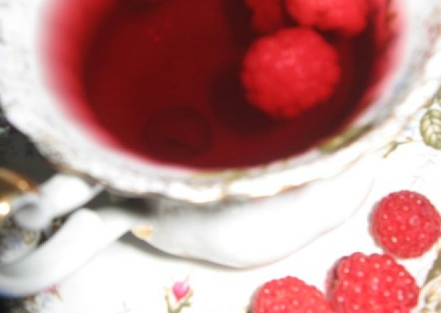 Fotografia przedstawiająca mrożona herbata malinowa ze świeżymi malinami