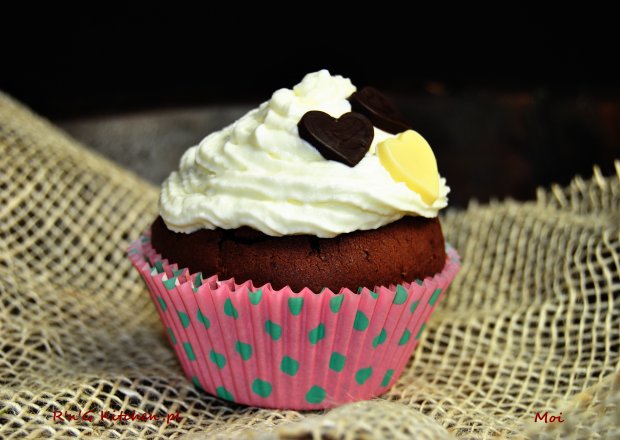 Fotografia przedstawiająca Muffinki czekoladowe z malinami i bitą śmietaną