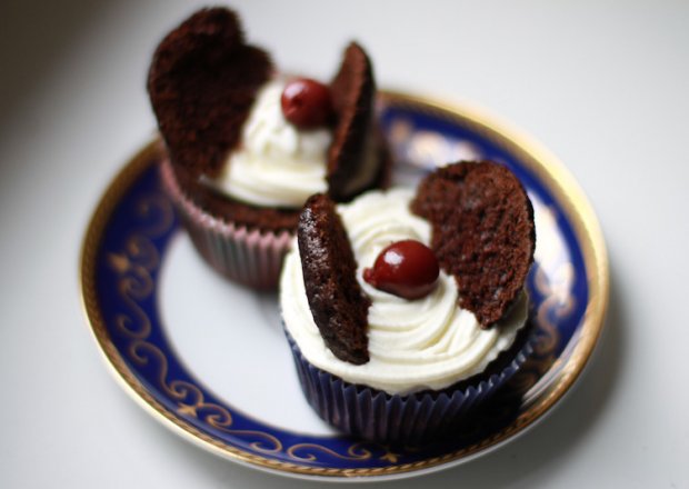 Fotografia przedstawiająca Muffinkowe czekoladowo-wiśniowe motylki z rumem przykryte puszystym kremem z mascarpone