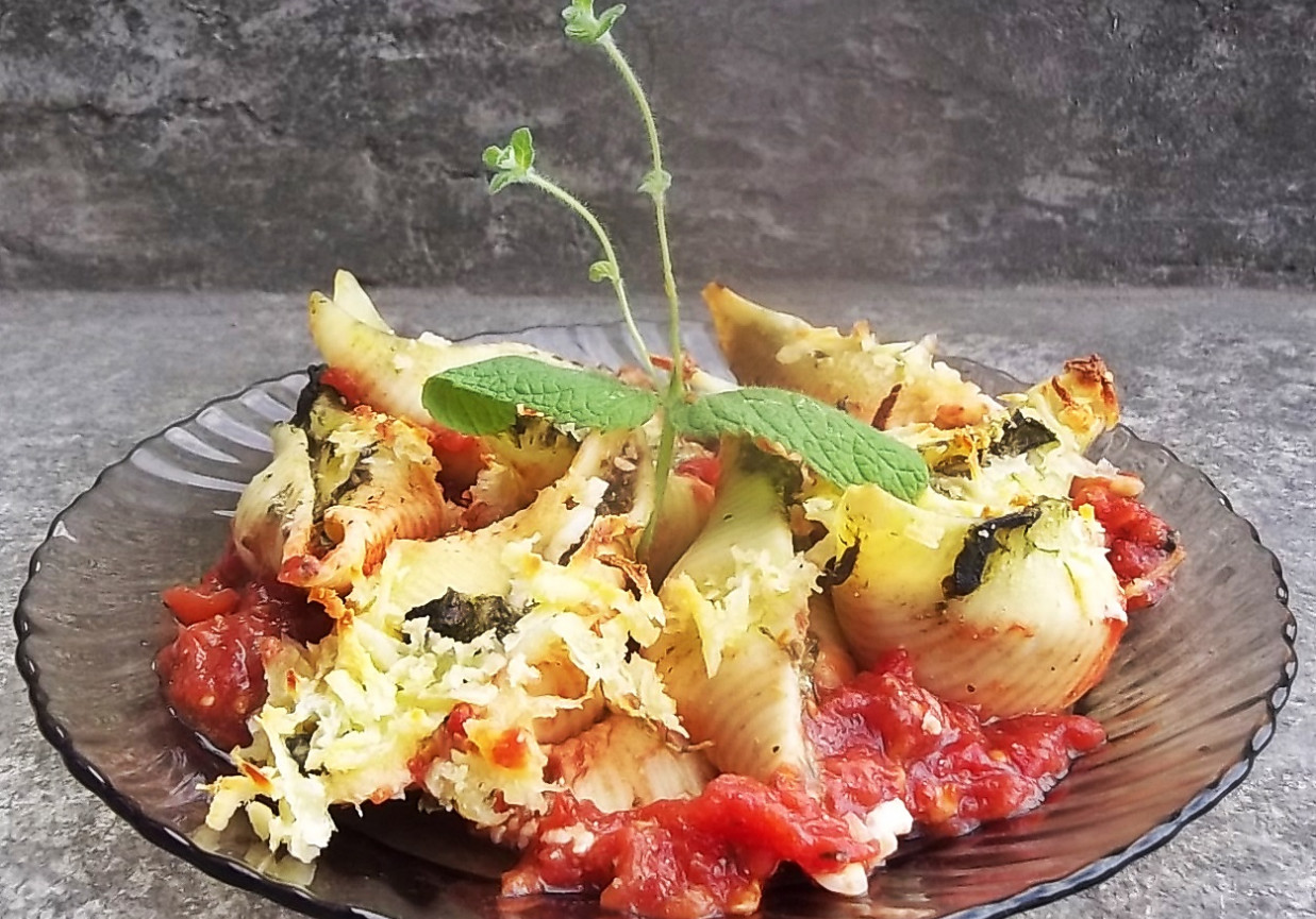Muszle conchiglioni ze szpinakiem i serem na pomidorach foto