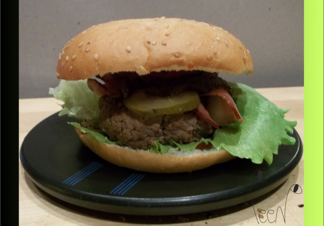 Musztardowy hamburger z grilowanym boczkiem, kiszonym ogórkiem i karmelizowaną w miodzie cebulą foto