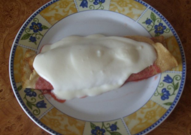 Fotografia przedstawiająca Naleśniki z sosem truskawkowym i bitą śmietaną
