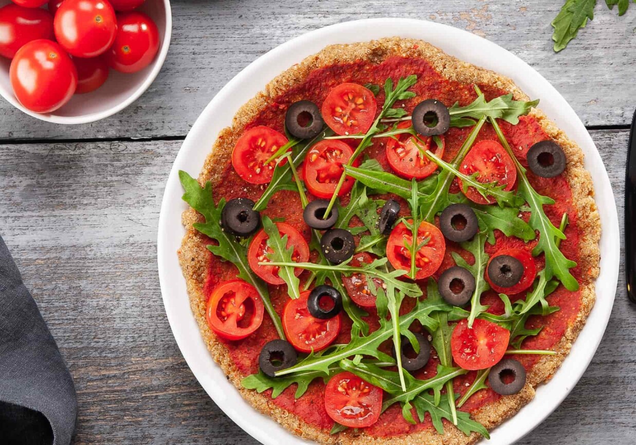Obiad: Pizza na spodzie z komosy ryżowej z pomidorkami, oliwkami i rukolą foto
