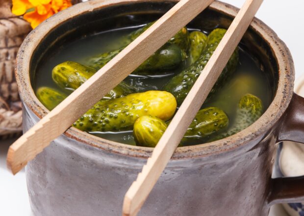 Fotografia przedstawiająca Ogórki  kiszone w wiaderku z selerem