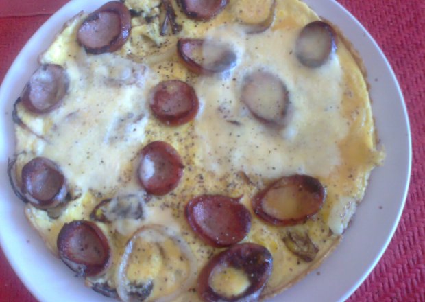 Fotografia przedstawiająca omlet z kiełbasą, cebulą i żółtym serem