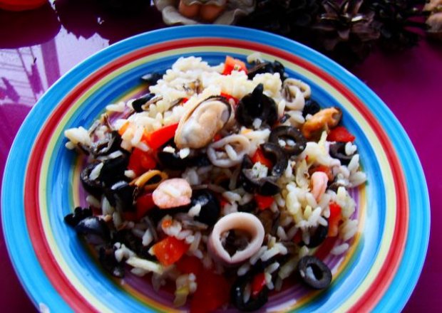 Fotografia przedstawiająca owoce morza z ryżem i oliwkami
