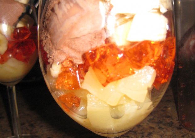 Fotografia przedstawiająca owocowy deser z galaretką i lodami