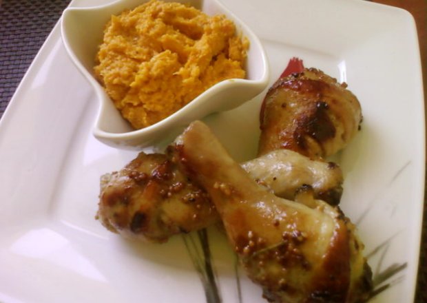 Fotografia przedstawiająca Pałki z kurczaka marynowane w miodzie i musztardzie z dodatkiem puree marchewkowo kukurydzianym