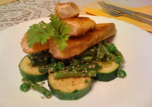 Fotografia przedstawiająca Paluszki z łososia na sałatce z zielonych warzyw z sezamem