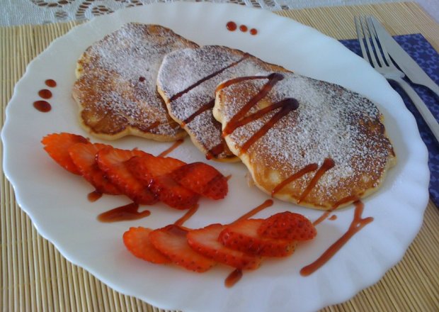 Fotografia przedstawiająca Pancakes - amerykańskie naleśniki z truskawkami i malinowym sosem balsamicznym