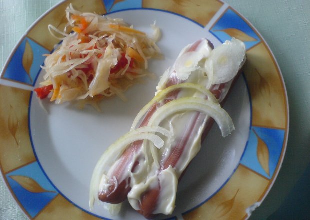 Fotografia przedstawiająca parówki z majonezem i cebulą oraz surówką